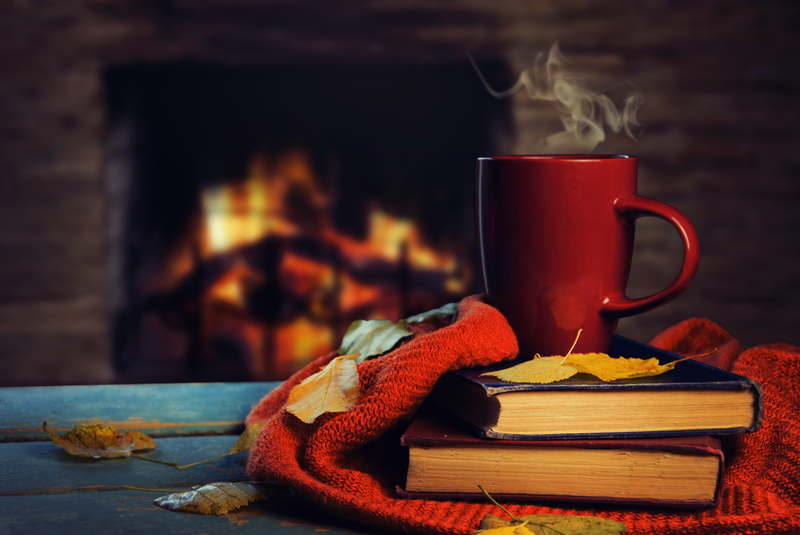 Taza y libros frente a chimenea